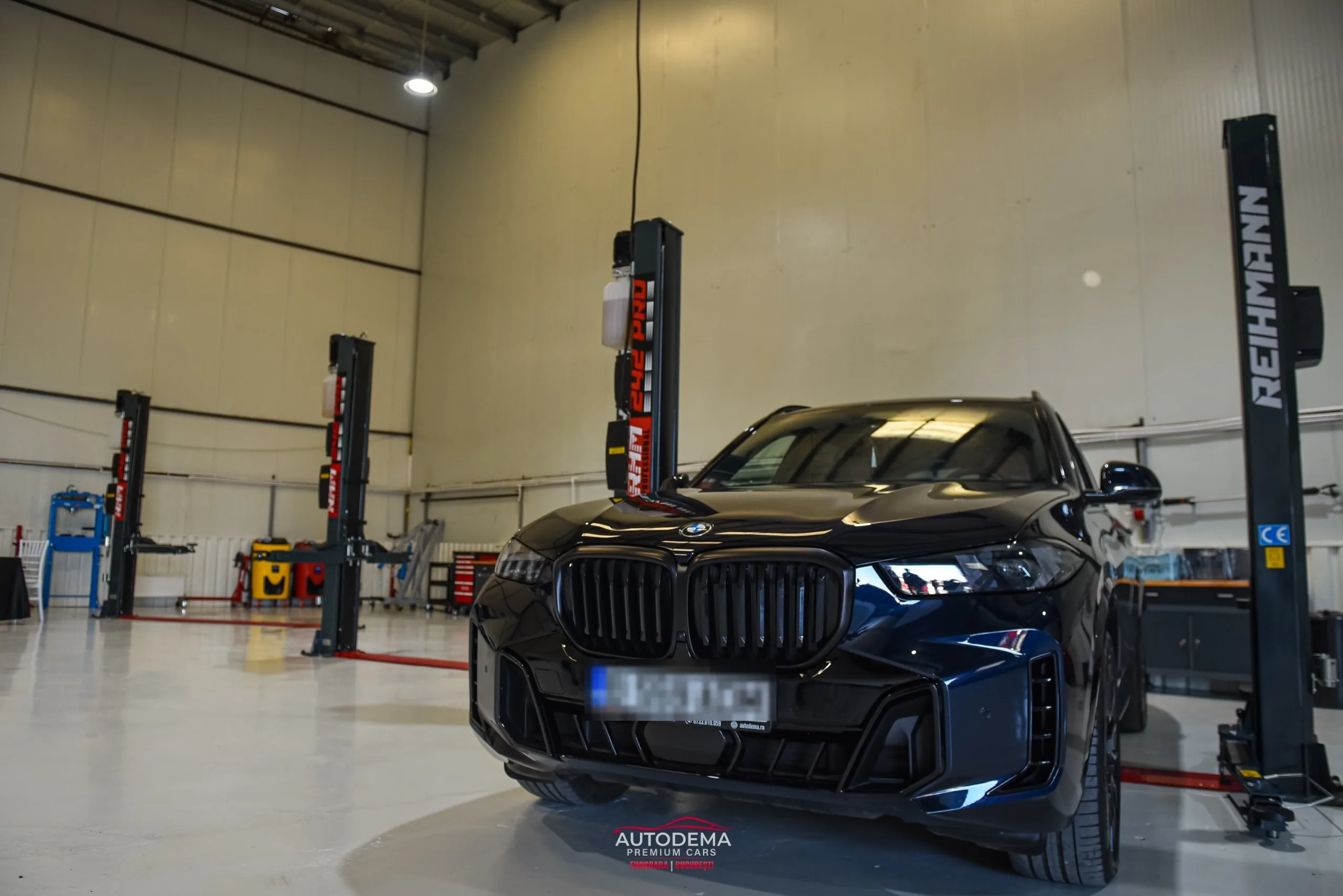 Hala sediului AUTODEMA din Otopeni, cu un SUV între elevatoare cu două coloane